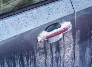 Frozen car door handle covered with ice.