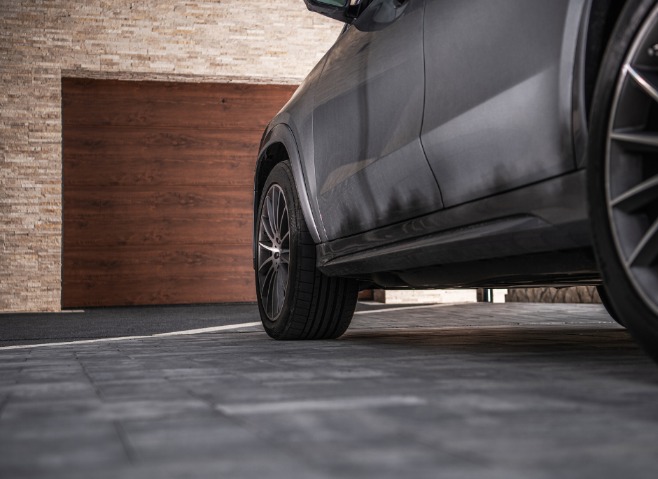 Modern SUV parked outside wooden garage door.