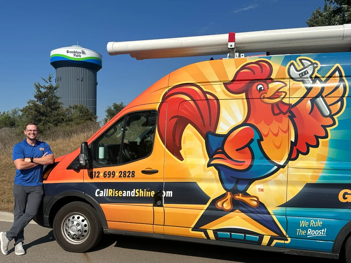 Alex, owner of Rise & Shine Garage Doors, is standing in front of his van in Brooklyn Park, MN.