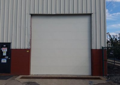 Large white commercial garage door exterior view.