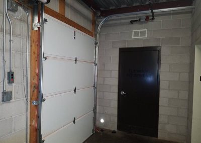 Garage door beside elevator equipment room door.