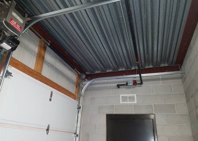 Overhead garage door track near elevator door.