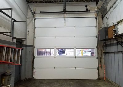 White commercial garage door with narrow windows.