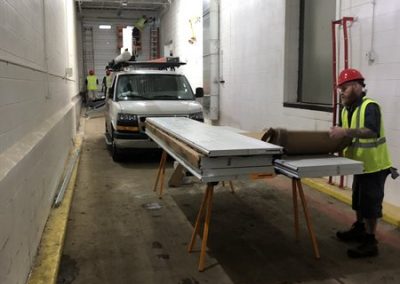 Worker assembling garage door panels indoors.