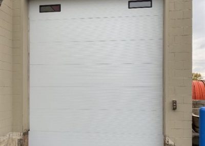 White commercial garage door with small windows.