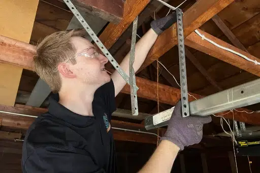 A technician performing a service on a garage door.